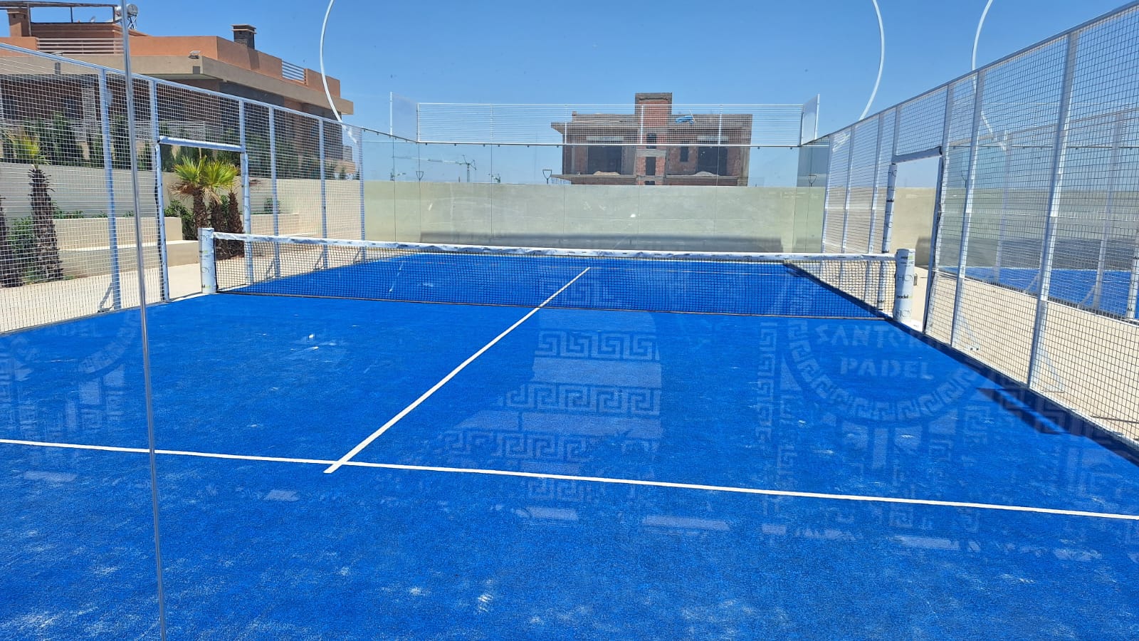 Terrain de padel Santorini avec palmiers en arrière-plan